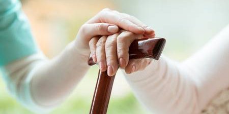 88394349-senior-holding-hands-on-walking-cane-and-nurse-supporting-her-in-nursing-home
